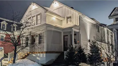 a white house with a staircase in front of it at Most beautiful condo 101 in Bromont Vieux in Bromont