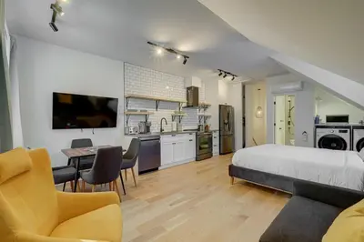 a bedroom with a bed and a table and a kitchen at Loft at 913 Shefford in Bromont