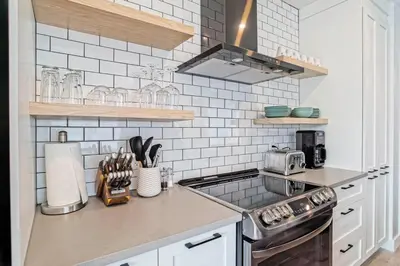 a kitchen with white subway tiles and a stove at Loft at 913 Shefford in Bromont