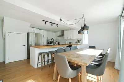 a kitchen and dining room with a wooden table and chairs at 891 shefford 4-bedroom house in Bromont