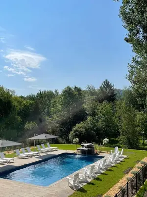 a pool with white lounge chairs and a fountain at 891 shefford 4-bedroom house in Bromont