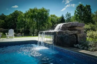 a swimming pool with a fountain in a yard at 891 shefford 4-bedroom house in Bromont