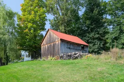 an old barn with a red roof on a field at 891 shefford 4-bedroom house in Bromont