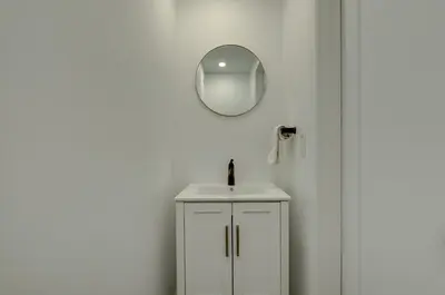 a white bathroom with a sink and a mirror at 951 Shefford 4 bedrooms house in Bromont