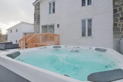 a hot tub on a patio in front of a house at 951 Shefford 4 bedrooms house in Bromont