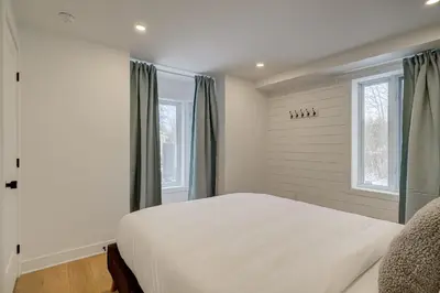 a bedroom with a large white bed and windows at 951 Shefford 4 bedrooms house in Bromont