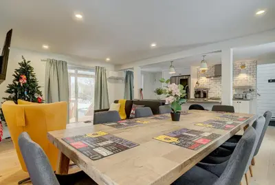 a dining room table with chairs and a christmas tree at 951A Shefford Bromont 3 bedrooms in Bromont