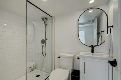 a bathroom with a shower and a toilet and a mirror at 951A Shefford Bromont 3 bedrooms in Bromont