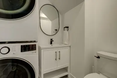 a bathroom with a washing machine and a mirror at 951A Shefford Bromont 3 bedrooms in Bromont