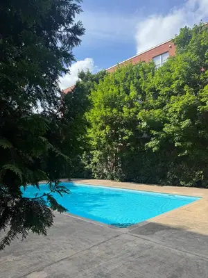 a blue swimming pool with trees and a building at Spacious Condo with a Bright Interior in Montréal