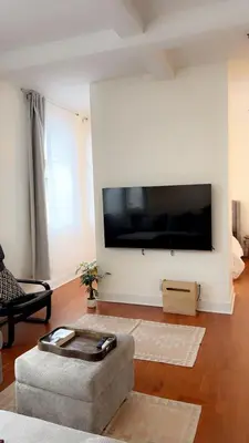 a living room with a large flat screen tv on a wall at Spacious Condo with a Bright Interior in Montréal