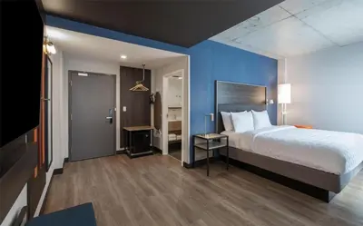 a bedroom with a bed and a blue wall at Tru By Hilton Montréal centre-ville in Montréal