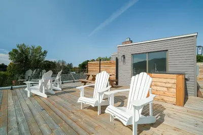 a deck with white chairs and a table and a building at room with private bathroom 837 shefford suite 105 in Bromont