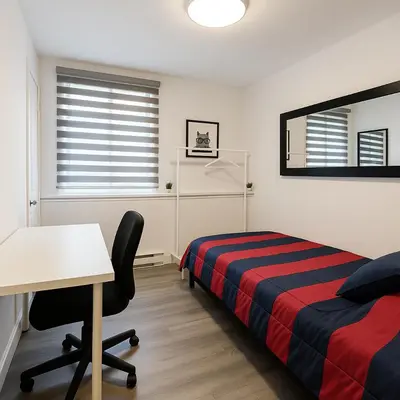 a bedroom with a bed and a desk and a table at Grand Appartement 4 Chambres Rénové et Meublé in Montréal