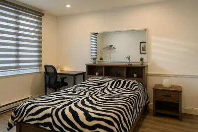 a bedroom with a zebra print bed and a mirror at Grand Appartement 4 Chambres Rénové et Meublé in Montréal