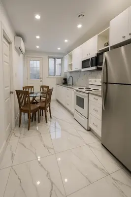 a kitchen with a table and chairs and a refrigerator at Grand Appartement 4 Chambres Rénové et Meublé in Montréal