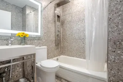 a bathroom with a toilet and a tub and a sink at Olympia Hotel by Lodgo in Montréal
