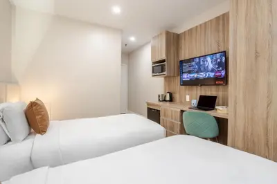 a hotel room with two beds and a tv at Olympia Hotel by Lodgo in Montréal