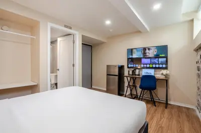 a bedroom with a bed and a flat screen tv at Olympia Hotel by Lodgo in Montréal