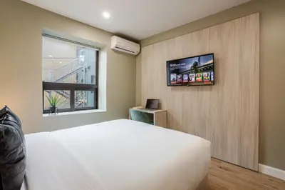 a bedroom with a bed and a tv on a wall at Olympia Hotel by Lodgo in Montréal