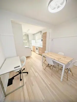 a white room with a wooden table and chairs at Appartement cosy au mois proche du Stade Olympique in Montréal