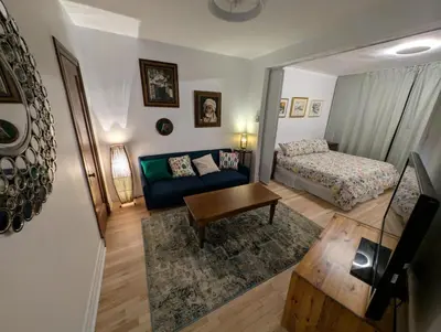 a living room with a couch and a bed at Appartement cosy au mois proche du Stade Olympique in Montréal
