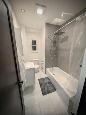 a bathroom with a shower and a tub and a sink at Appartement cosy au mois proche du Stade Olympique in Montréal