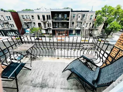 a group of chairs and tables on a balcony at Homa 1 in Montréal