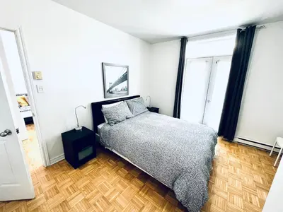 a bedroom with a bed and two windows at Homa 1 in Montréal