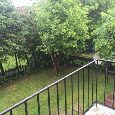 a balcony with a fence and a park with a bench at Charming Vintage Home Park View Family-Ready in Montréal
