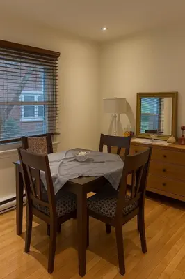 a dining room with a table and chairs and a mirror at Charming Vintage Home Park View Family-Ready in Montréal