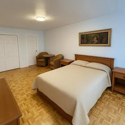 a bedroom with a large bed and a chair at Chic 3BR Stay in Laval, Bright and Peaceful in Laval