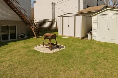 a stool sitting in the middle of a yard at Chic 3BR Stay in Laval, Bright and Peaceful in Laval