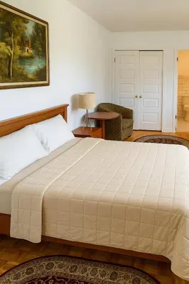 a bedroom with a large bed and a living room at Chic 3BR Stay in Laval, Bright and Peaceful in Laval