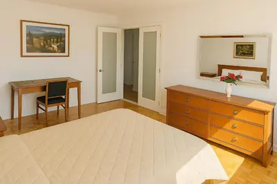 a bedroom with a dresser and a desk and a mirror at Chic 3BR Stay in Laval, Bright and Peaceful in Laval
