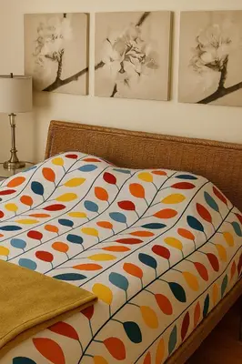 a bed with a colorful comforter in a bedroom at Sunny & Peaceful 1BR, Walk to UdM, HEC & Hospital in Montréal