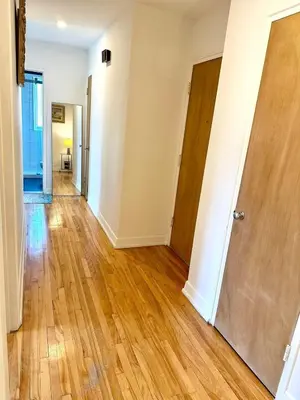 an empty hallway of an apartment with wooden floors at Sunny & Peaceful 1BR, Walk to UdM, HEC & Hospital in Montréal