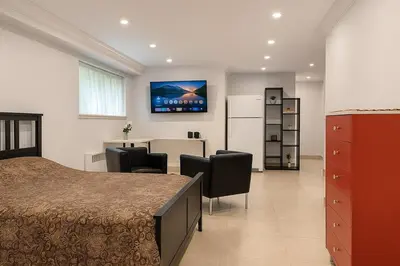 a bedroom with a bed and a table and chairs at Stylish Furnished Modern Studio, Bright and Spacious 20 Minutes from Downtown in Montréal