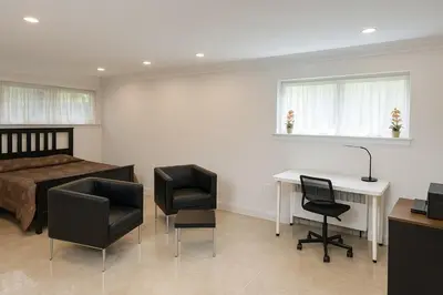 a bedroom with a bed and a desk and chairs at Stylish Furnished Modern Studio, Bright and Spacious 20 Minutes from Downtown in Montréal
