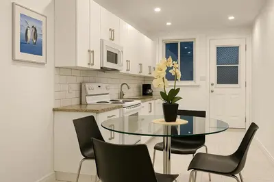 a kitchen with a glass table with chairs and a sink at Bright Renovated 4BR, Heart of Côte-des-Neiges, Montreal in Montréal
