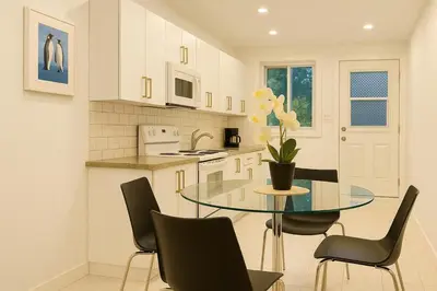 a kitchen with a glass table and black chairs at Bright Renovated 4BR, Heart of Côte-des-Neiges, Montreal in Montréal