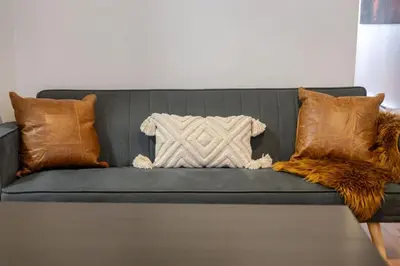 a gray couch with pillows and a blanket on it at Central 3BR downtown MTL Plateau Mont Royal in Montréal