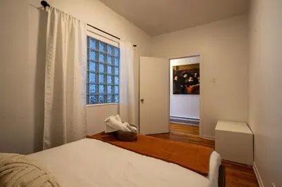 a bedroom with a bed and a large window at Central 3BR downtown MTL Plateau Mont Royal in Montréal