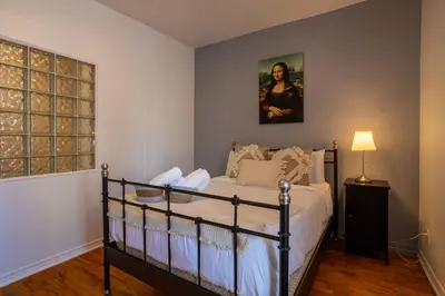 a bedroom with a bed and a painting on the wall at Central 3BR downtown MTL Plateau Mont Royal in Montréal