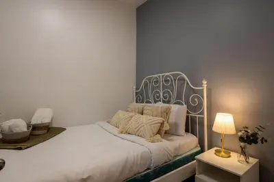 a bedroom with a white bed with a metal headboard at Central 3BR downtown MTL Plateau Mont Royal in Montréal