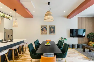 a dining room with a black table and green chairs at Le Galeria, MTLVR in Montréal