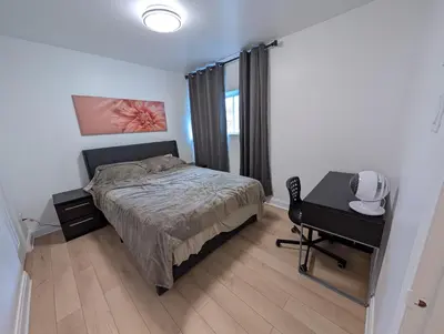 a bedroom with a bed and a desk with a desk at Stay close to Montreal in Longueuil