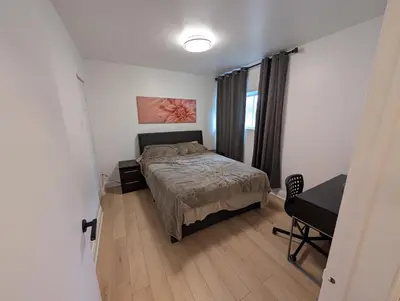 a small bedroom with a bed and a desk at Stay close to Montreal in Longueuil