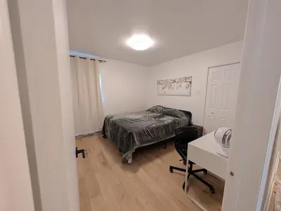 a bedroom with a bed and a desk and a table at Stay close to Montreal in Longueuil