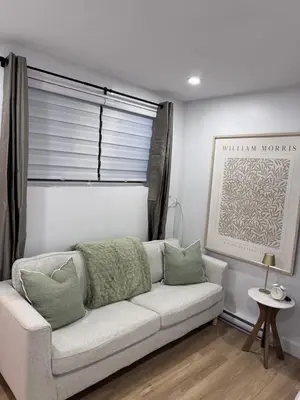 a white couch in a living room with a window at Casa Samson in Laval